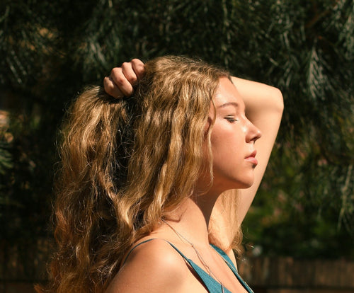 woman caressing her scalp and hair