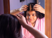 woman looking at her scalp in the mirror