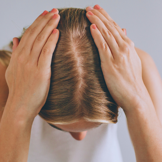 woman touching her thinning hair